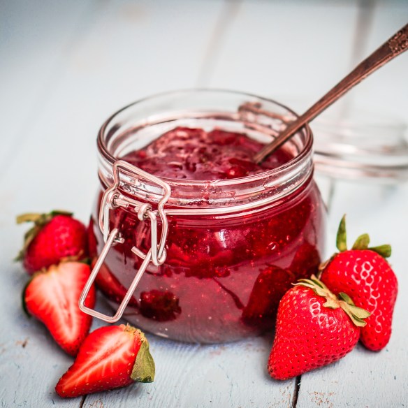 Strawberry jam in a jar on wooden background