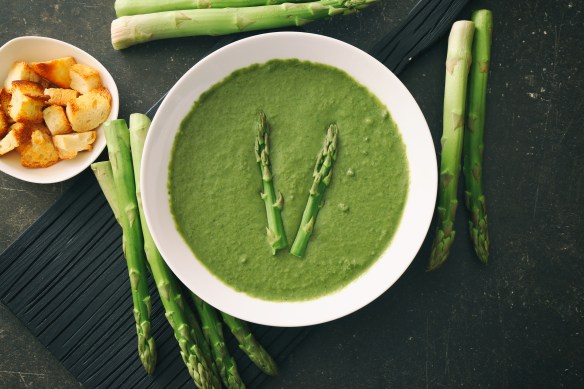 Tasty asparagus soup on table